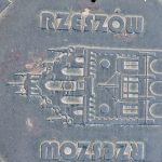 Właz do studzienki kanalizacyjnej w Rzeszowie, przedstawia zabytek i napis Rzeszów)